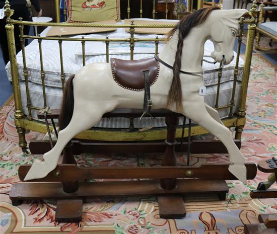 A Victorian-style rocking horse with leather saddle on mahogany safety frame L.135cm